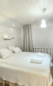 una camera da letto con un grande letto bianco con due cuscini di Petsukka Levi a Levi