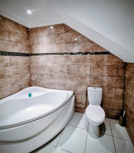 a bathroom with a white tub and a toilet at La maison du château in Saint-Victurnien