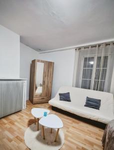 a living room with a white couch and a table at La maison du château in Saint-Victurnien