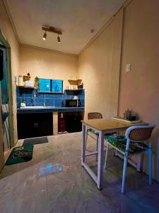 een keuken met een tafel en een tafel met stoelen bij Palm Haven w Starlink in Siquijor