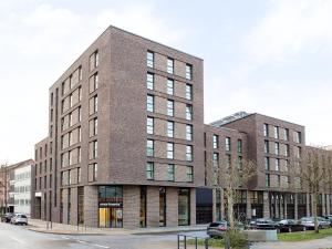 a large brick building on a street with parked cars at smartments Hamburg Hamm in Hamburg