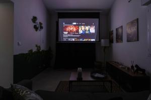 a living room with a large screen tv in a living room at Jungle Room avec Jacuzzi privé in Bastelicaccia