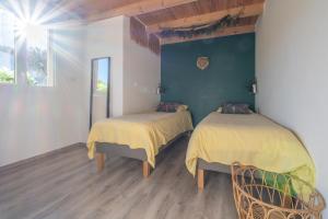 a bedroom with two beds with yellow sheets on them at Jungle Room avec Jacuzzi privé in Bastelicaccia +4 photos