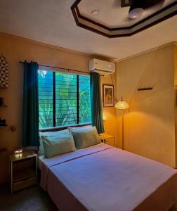 een slaapkamer met een groot bed met een groot raam bij Palm Haven w Starlink in Siquijor