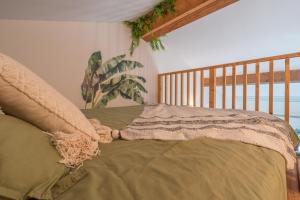 a bed with a blanket on it in a room at Jungle Room avec Jacuzzi privé in Bastelicaccia