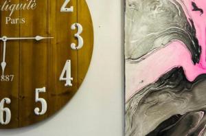 a wooden clock on a wall with a painting on it at Plaza Mayor de Leon in León