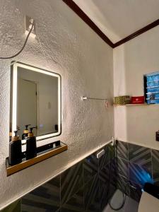 een badkamer met een wastafel en een spiegel aan een muur bij Palm Haven w Starlink in Siquijor