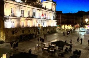 a group of people standing outside of a building at night at Plaza Mayor de Leon in León