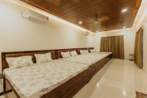 Кровать или кровати в номере Kaustubh farm by Classy stay