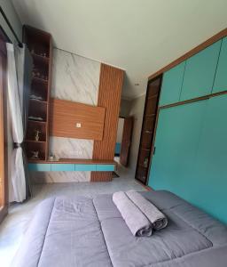 a bedroom with a bed with a towel on it at Bumbab House by Pigeon in Nusa Dua +7 photos