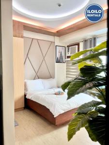 een klein bed in een kamer met een plant bij Relax Stay at One Madison Tower in Cari Mayor