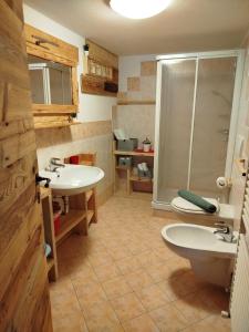 un baño con dos lavabos y una ducha en Botton d'oro, en Campitello di Fassa 6 fotos más