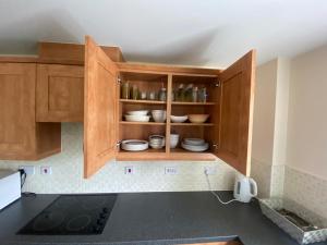 a kitchen with wooden cabinets with dishes in it at Friars terrace in Stafford