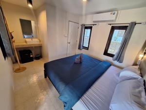 a bedroom with a bed with a blue blanket on it at So Good in Pai