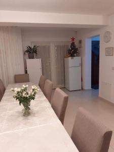 Una habitación con una mesa con un jarrón de flores encima. en Casa Anna, en Borşa