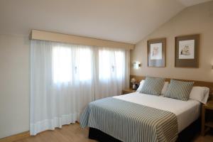 马德里Windsor Puerta del Sol的一间卧室，里面有一张床和一扇大窗户。