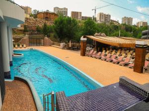 a large swimming pool with chairs next to a building at Armenian Village Park Hotel & FREE Water Park, GYM in Yerevan
