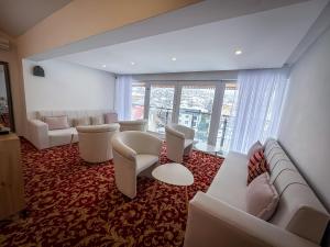 a living room with couches and chairs and a large window at Residence Mahala - Boutique Stay Near Old Town in Sarajevo
