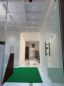 a hallway with a green carpet in a building at Hotel Tulip Inn & Lodging in Viravdi +6 photos