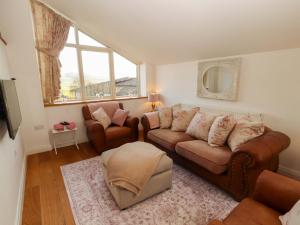 a living room with a couch and two chairs at Hawkrigg Cottage in Barbon