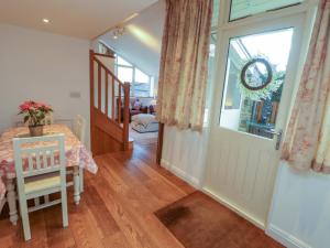 a dining room with a table and a glass door at Hawkrigg Cottage in Barbon