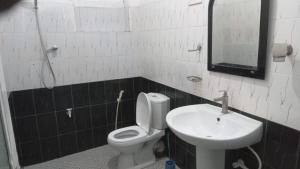 a bathroom with a sink and a toilet and a mirror at New Moon in Pannipitiya