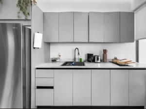 圣胡安Hyde Park 5 Elegant Comfy Apt in San Juan的带白色橱柜和水槽的厨房