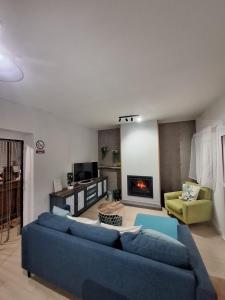 Una sala de estar con un sofá azul y una chimenea. en Casa cerca de el Barco de Ávila, Piedrahíta y La Covatilla Casa cruce de los molinos, en La Aldehuela