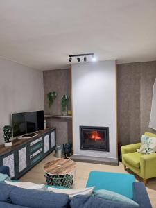 Una sala de estar con un sofá y una chimenea. en Casa cerca de el Barco de Ávila, Piedrahíta y La Covatilla Casa cruce de los molinos, en La Aldehuela