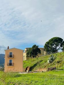 una casa en la cima de una colina cubierta de hierba en Tenute Pacelli - Azienda Agricola, en Malvito
