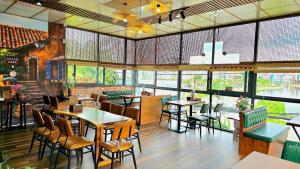 a restaurant with tables and chairs and windows at Mi Lan Boutique Resort in Vung Tau