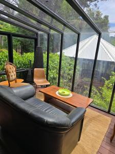 a living room with a leather couch and a table at Nottingham way Homestay in Blackwood
