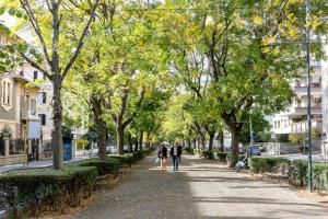 two people walking down a tree lined street at LAROS Dimora Dorica in Ancona