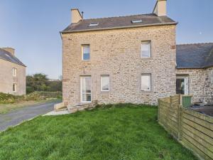 a brick house with a grass yard in front of it at Maison pour 7 avec jardin - Quartier paisible in Plouguerneau