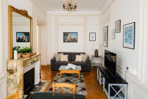 un salon avec un canapé et une cheminée dans l'établissement St André Centre Rouen Standing, à Rouen