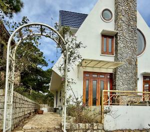 an entrance to a white house with a red door at Khu ngỉ dưỡng Tâm Anh Đà Lạt in Ấp Man Ling