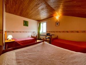 a bedroom with two beds and a wooden ceiling at Chambre Saumon, La Prairie in Pourcharesse
