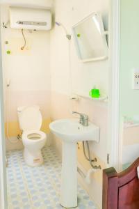 a small bathroom with a toilet and a sink at Quang Linh Motel Thanh Hóa in Thanh Hóa +2 photos