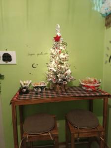 a small christmas tree on a table with two chairs at Il sentiero delle fate in Caserta