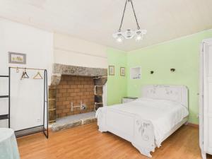 a bedroom with a white bed and a fireplace at Idéal pour 2 en pleine campagne avec jardin in Plouguerneau