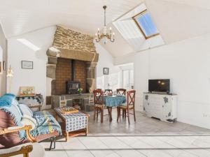 a living room with a fireplace and a table and chairs at Idéal pour 2 en pleine campagne avec jardin in Plouguerneau