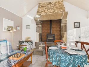 a living room with a table and a fireplace at Idéal pour 2 en pleine campagne avec jardin in Plouguerneau