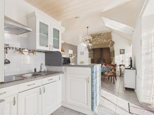 a kitchen with white cabinets and a dining room at Idéal pour 2 en pleine campagne avec jardin in Plouguerneau +8 photos