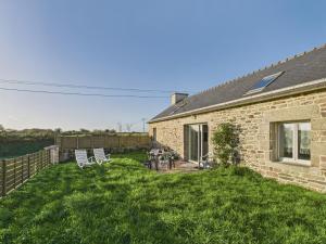 a backyard of a brick house with chairs at Idéal pour 2 en pleine campagne avec jardin in Plouguerneau