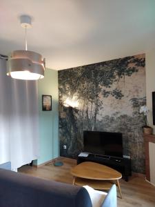 a living room with a large painting on the wall at Studio neuf équipé, confortable et au calme in Issoire +12 photos
