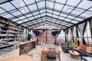 a conservatory with a glass ceiling and tables and chairs at Gervasia Hotel Makati in Manila