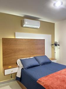a bedroom with a blue bed with a wooden headboard at New ground floor apartment, very comfortable and excellent location in Mazatlán