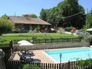 ein Pool mit Stühlen und einem Sonnenschirm und ein Haus in der Unterkunft Agriturismo Ponte Di Riocchio in Gubbio