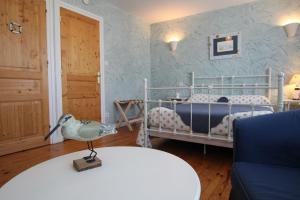 a bedroom with a bed and a table with a lamp at Chambre Les Embruns, Le Petit Ruban in Saint-Just-Malmont