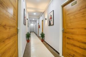 a hallway with two potted plants and a wooden door at FabHotel Sonnet Inns in Rānchī